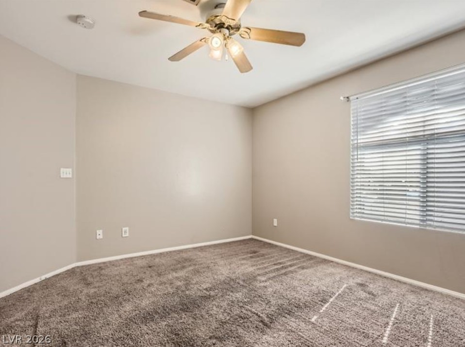 3950 South Sandhill Road, Unit 121 Las Vegas, NV 89121 - Photo 5 of 11 A comfortable bedroom with soft carpet flooring, complete with a ceiling fan for climate control.