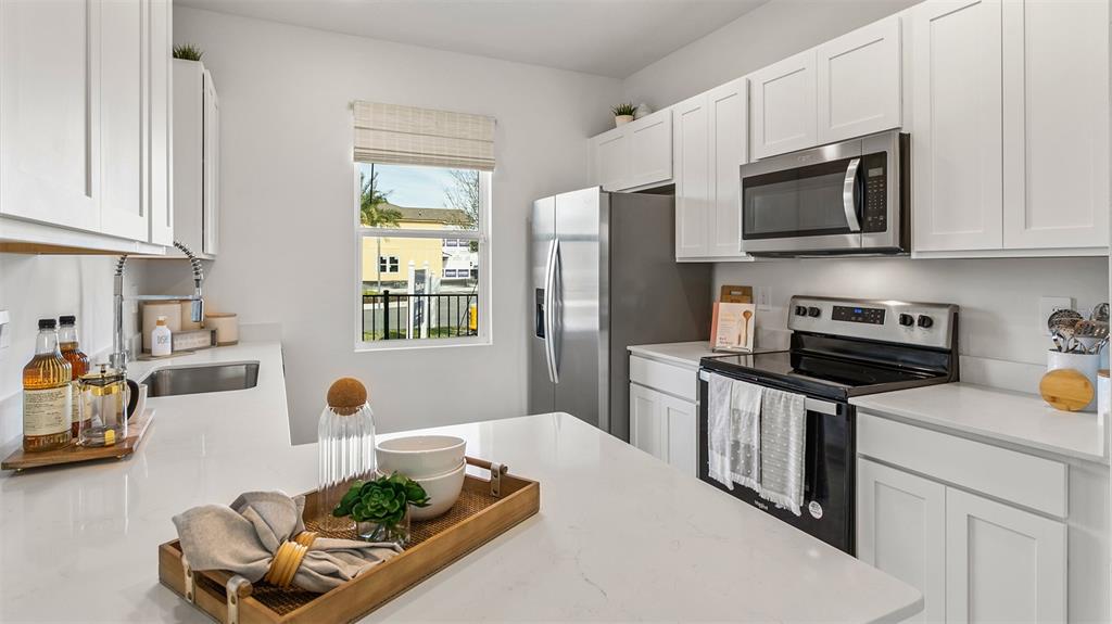 292 Palmetto Rdg Road St. Augustine, FL 32095 - Photo 8 of 37 a kitchen with stainless steel appliances a stove a sink a microwave a refrigerator and cabinets