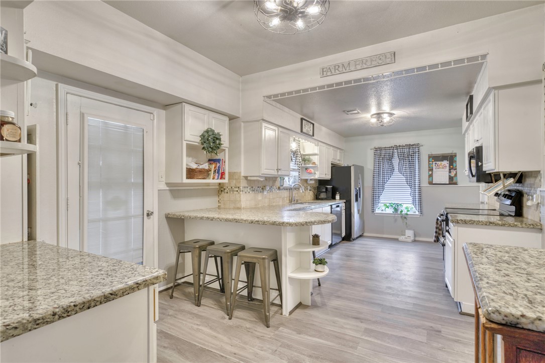 1681 Union Road Madisonville, TX 77864 - Photo 11 of 50 a kitchen with stainless steel appliances granite countertop a refrigerator a stove and a sink with wooden floor