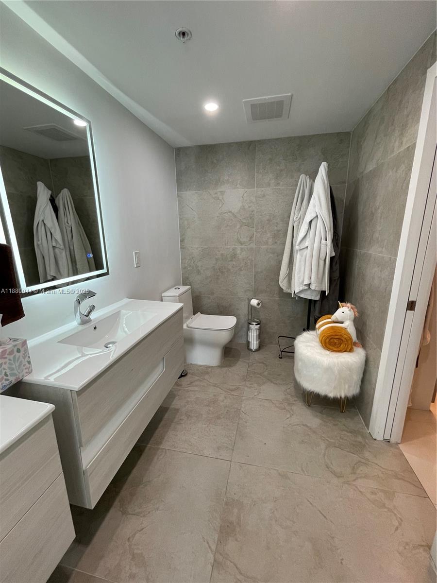 92 Southwest 3rd Street, Unit 1602 Miami, FL 33130 - Photo 15 of 48 a bathroom with a double vanity sink and a mirror