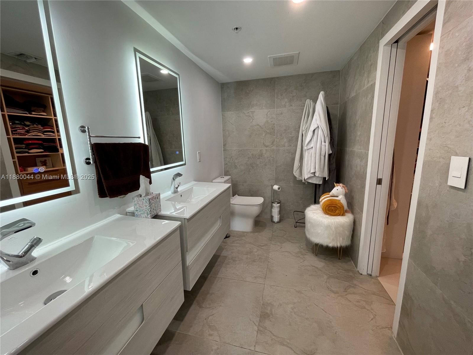 92 Southwest 3rd Street, Unit 1602 Miami, FL 33130 - Photo 16 of 48 a bathroom with a double vanity sink and mirror