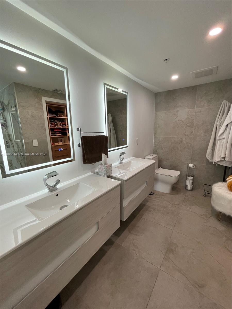 92 Southwest 3rd Street, Unit 1602 Miami, FL 33130 - Photo 17 of 48 a bathroom with a double vanity sink and a mirror