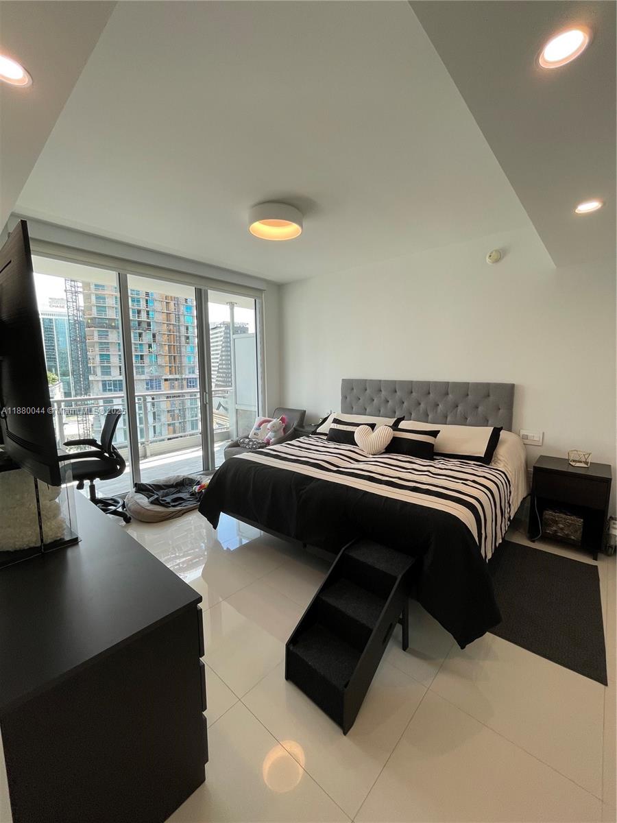 92 Southwest 3rd Street, Unit 1602 Miami, FL 33130 - Photo 20 of 48 a bedroom with a bed couch and a large window