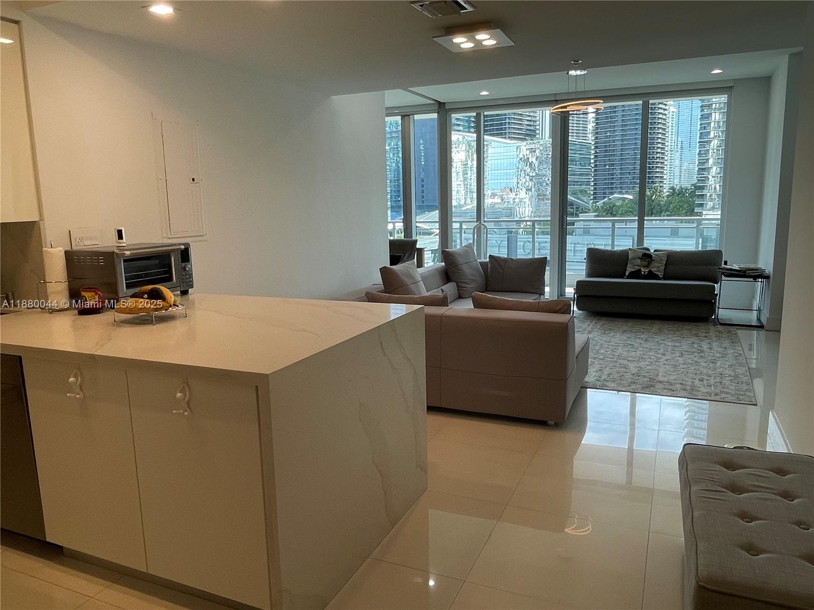 92 Southwest 3rd Street, Unit 1602 Miami, FL 33130 - Photo 2 of 48 a living room with furniture and a flat screen tv