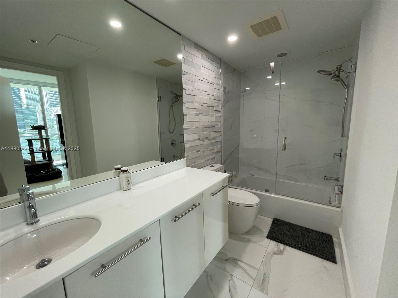 92 Southwest 3rd Street, Unit 1602 Miami, FL 33130 - Photo 25 of 48 a bathroom with a double vanity sink toilet mirror and shower