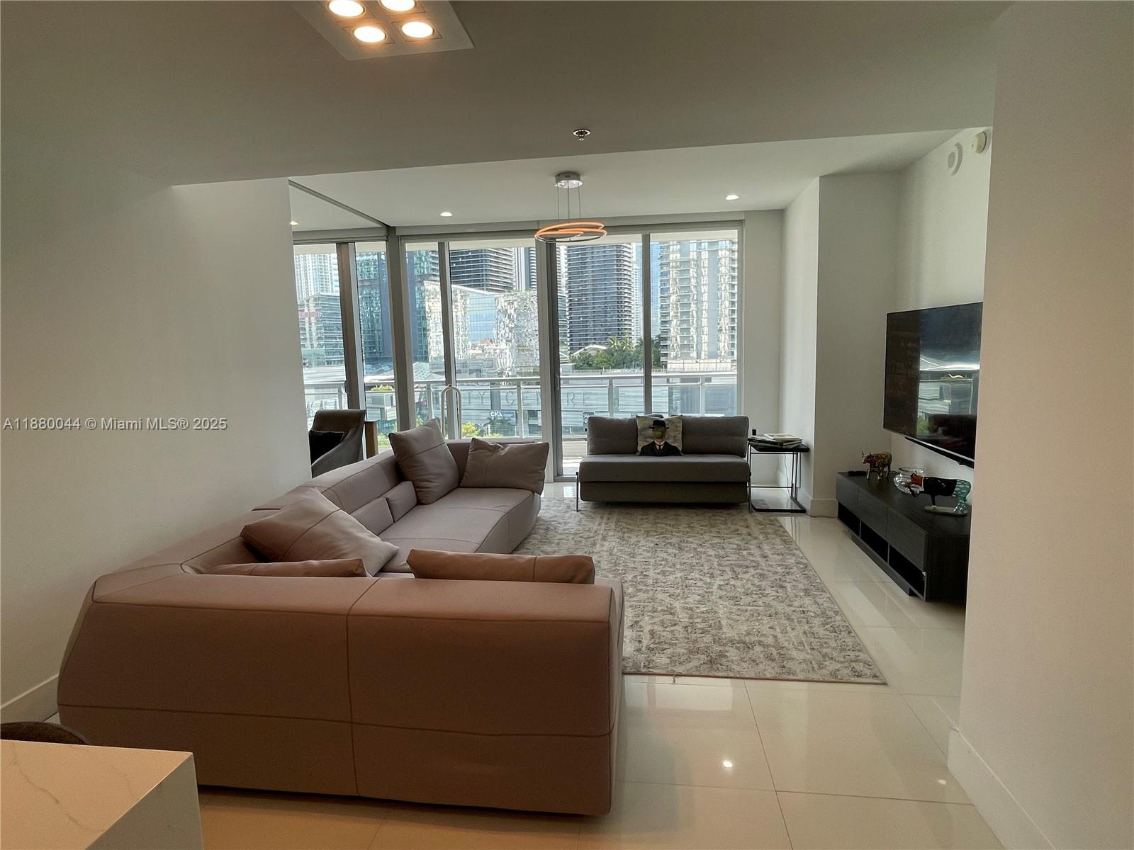 92 Southwest 3rd Street, Unit 1602 Miami, FL 33130 - Photo 29 of 48 a living room with furniture and a flat screen tv