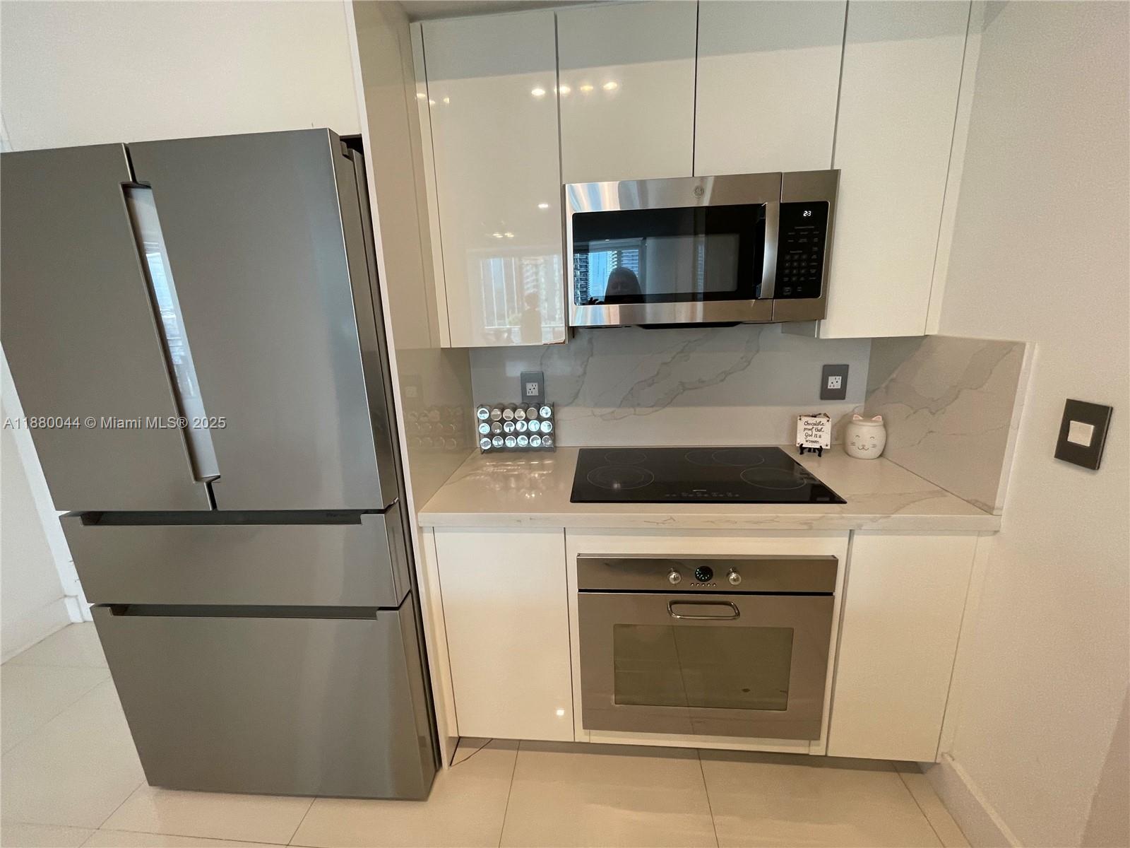 92 Southwest 3rd Street, Unit 1602 Miami, FL 33130 - Photo 3 of 48 a kitchen with stainless steel appliances a refrigerator a stove a microwave and cabinets