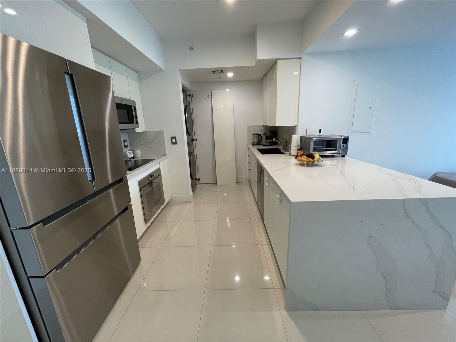 92 Southwest 3rd Street, Unit 1602 Miami, FL 33130 - Photo 4 of 48 a kitchen with refrigerator and car