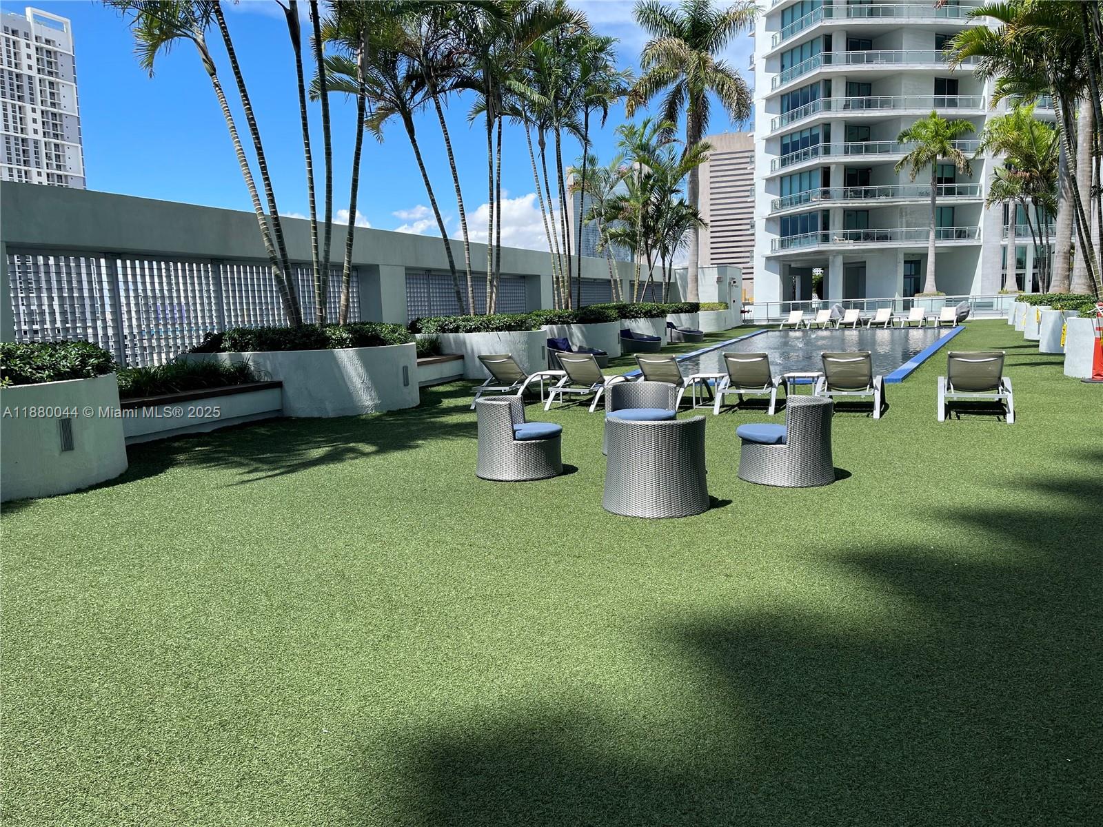 92 Southwest 3rd Street, Unit 1602 Miami, FL 33130 - Photo 46 of 48 a view of a patio with table and chairs potted plants and palm tree