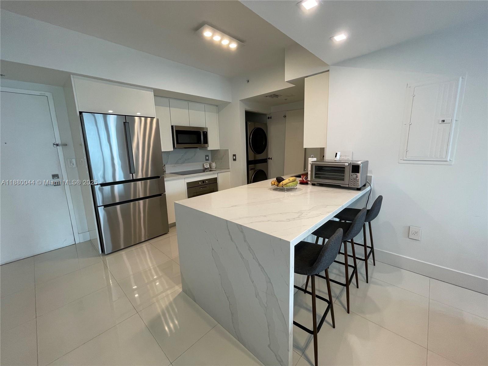 92 Southwest 3rd Street, Unit 1602 Miami, FL 33130 - Photo 5 of 48 a kitchen with stainless steel appliances a refrigerator and a stove top oven