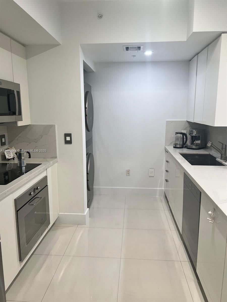 92 Southwest 3rd Street, Unit 1602 Miami, FL 33130 - Photo 9 of 48 a kitchen with a sink stove and microwave