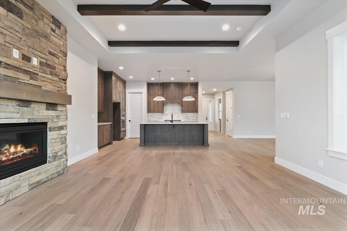 2147 East Blakehurst Avenue Kuna, ID 83634 - Photo 6 of 43 Unfurnished living room featuring light wood-style floors, a raised ceiling, recessed lighting, and ceiling fan