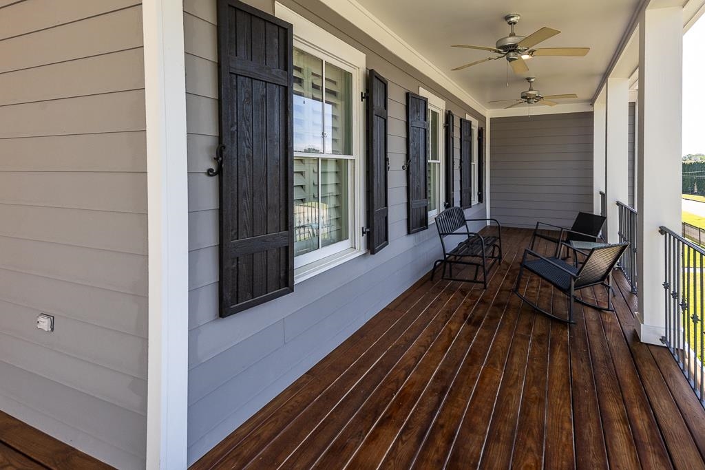 328 Washington Street Collierville, TN 38017 - Photo 22 of 33 Expansive covered porch featuring rich wood-finish flooring, multiple ceiling fans, gray horizontal siding, and decorative black window shutters