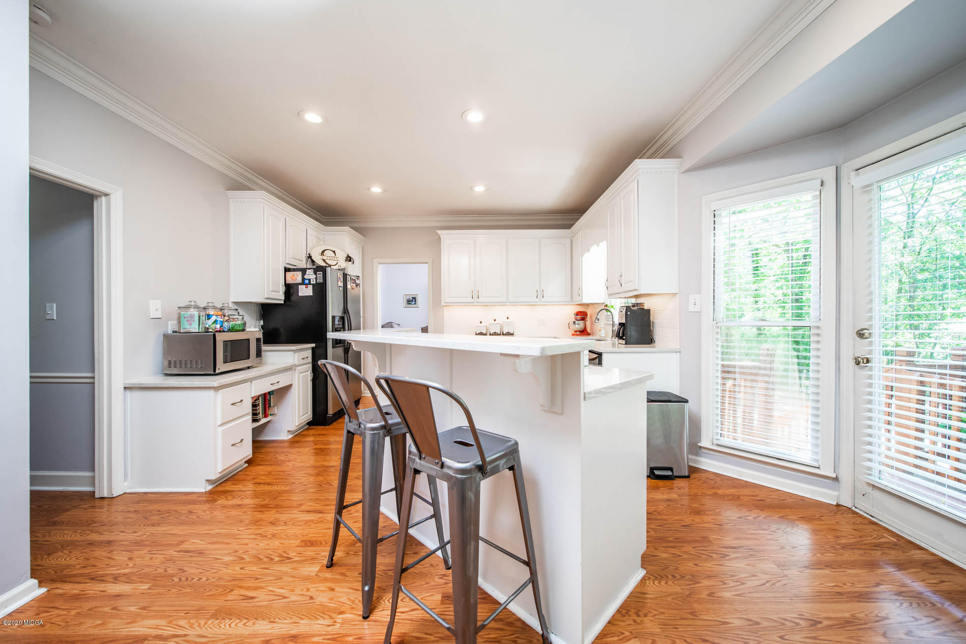 245 Beacon Hill Road Macon, GA 31210 - Photo 12 of 39 a kitchen with stainless steel appliances kitchen island granite countertop a refrigerator a sink a stove and white cabinets with wooden floor