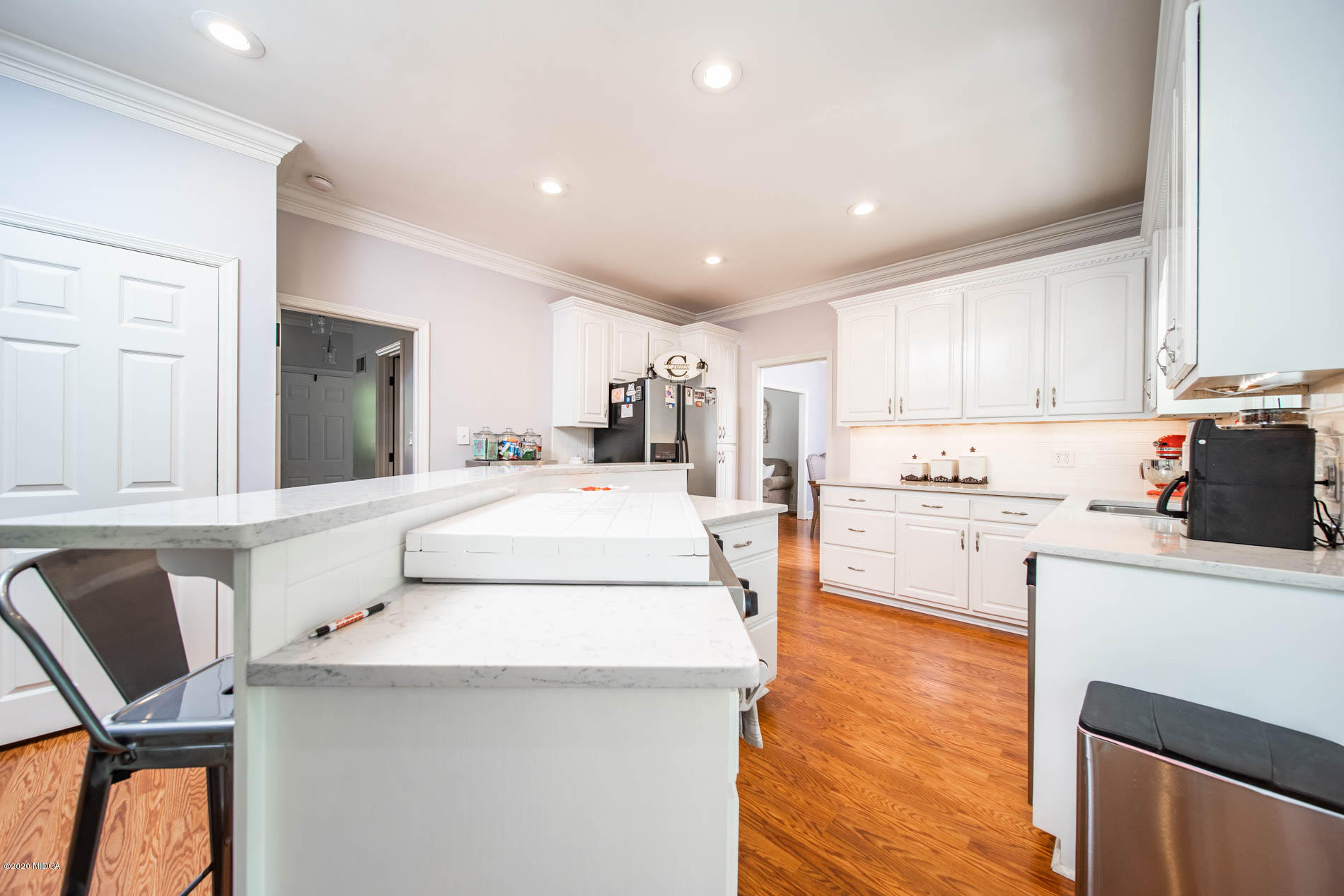 245 Beacon Hill Road Macon, GA 31210 - Photo 13 of 39 a kitchen with a stove a refrigerator and white cabinets with wooden floor