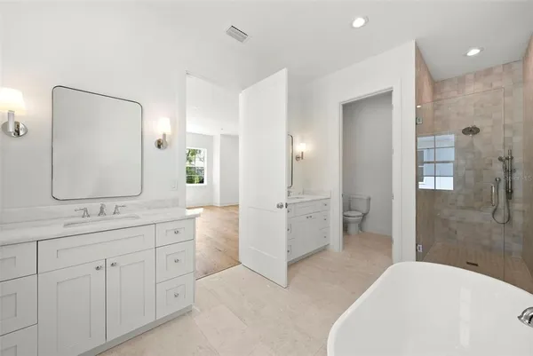 a spacious bathroom with a double vanity sink mirror and shower