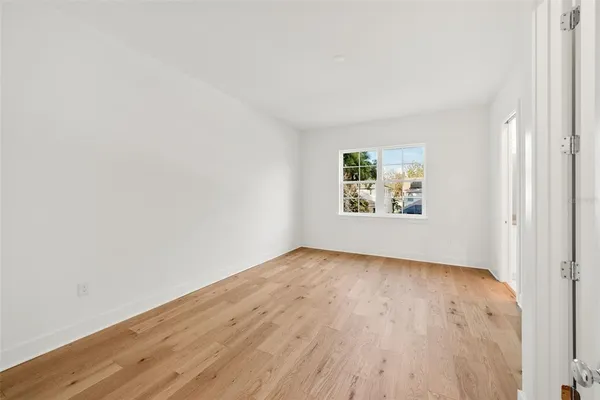 an empty room with wooden floor and window