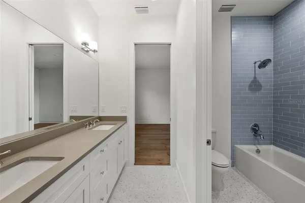 a bathroom with a tub a sink and mirrors