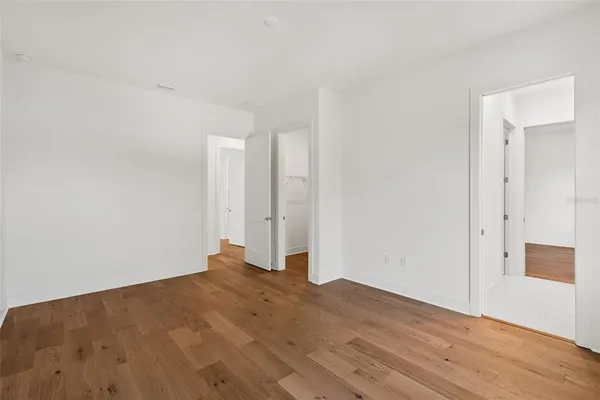 a view of empty room with wooden floor