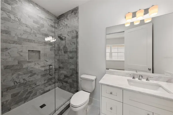 a bathroom with a sink a toilet and shower