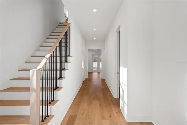 a view of a hallway with wooden floor and stairs