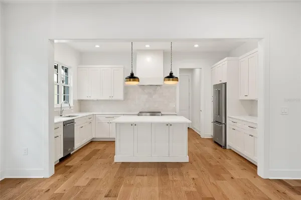 a kitchen with stainless steel appliances granite countertop a stove a sink and a refrigerator
