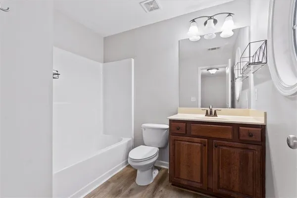 a spacious bathroom with a granite countertop sink a toilet and a mirror