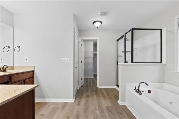 a bathroom with a tub sink and mirror
