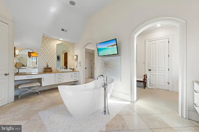 a view of a brick house with many windows and a table and chairs under an umbrella