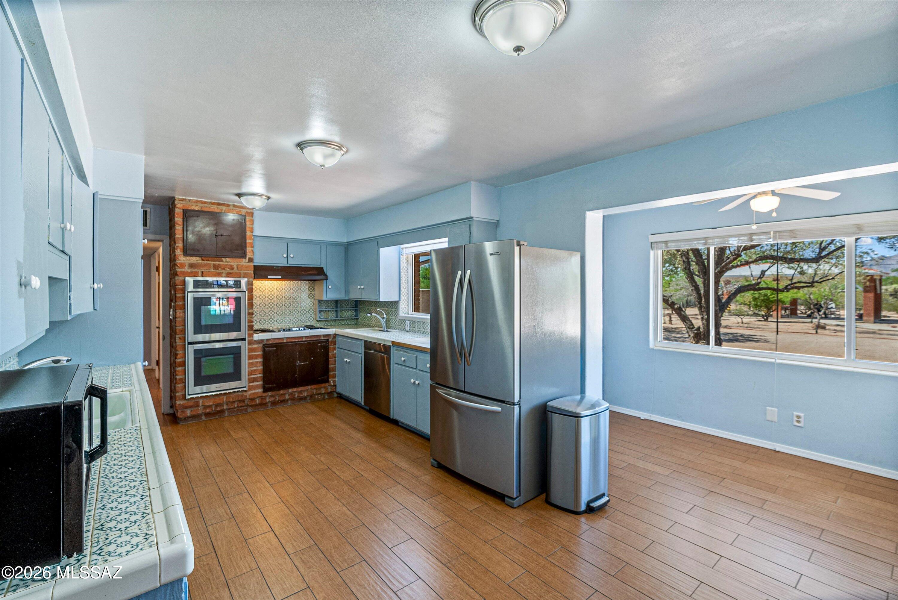2107 East Lind Road Tucson, AZ 85719 - Photo 14 of 43 a kitchen with stainless steel appliances granite countertop a refrigerator a stove and a wooden floors