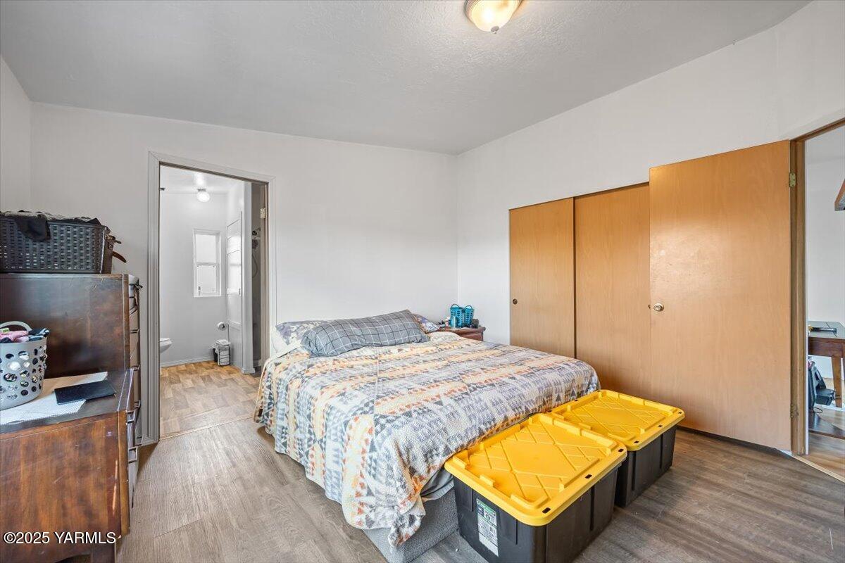183 Puterbaugh Road Grandview, WA 98930 - Photo 15 of 36 a bedroom with a bed and wooden floor