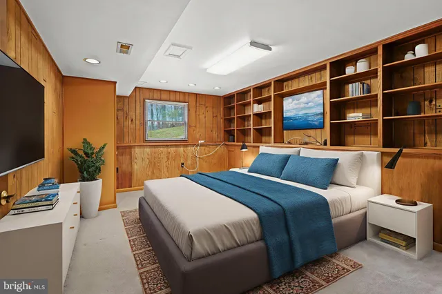 a bedroom with a large bed and a flat tv screen on dresser