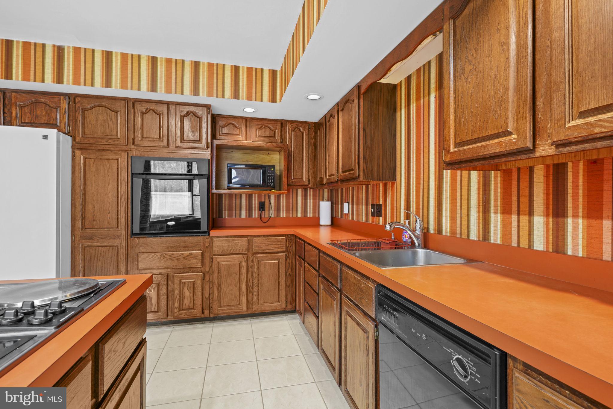 520 Chesapeake Beach Road Owings, MD 20736 - Photo 10 of 70 a kitchen with stainless steel appliances granite countertop a sink and cabinets