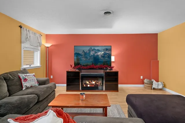 a living room with furniture a flat screen tv and a fireplace
