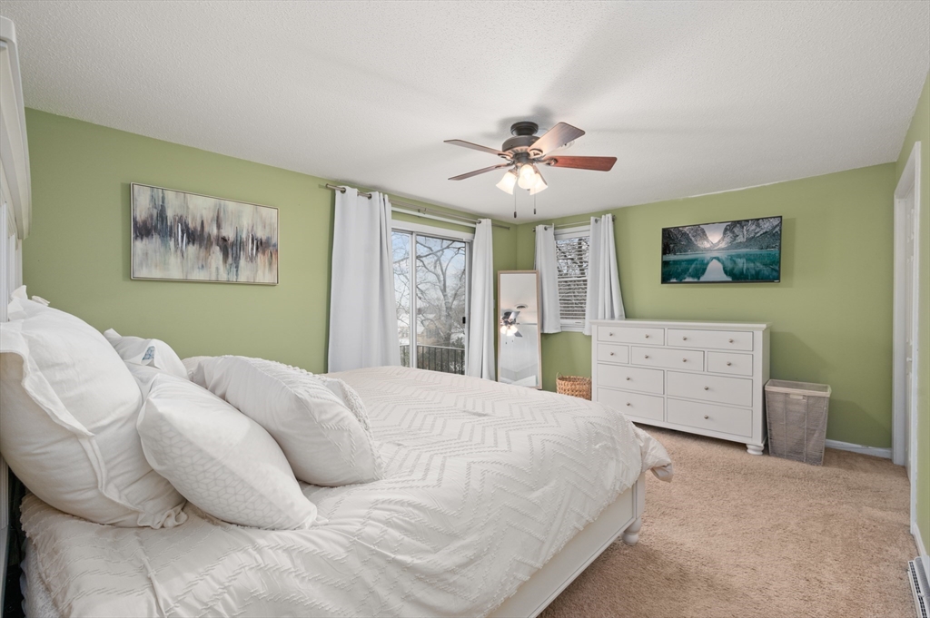 25 Shea Street, Unit 8 Dracut, MA 01826 - Photo 28 of 37 a spacious bedroom with a bed and a painting on the wall