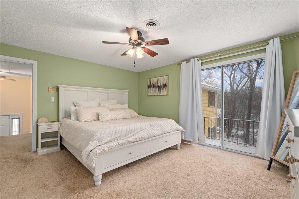 25 Shea Street, Unit 8 Dracut, MA 01826 - Photo 29 of 37 a spacious bedroom with a bed and a chandelier
