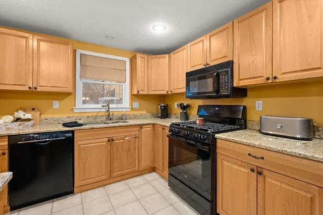a kitchen with granite countertop a stove top oven microwave and cabinets