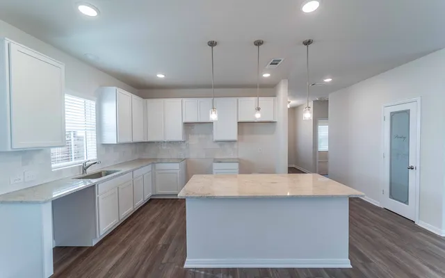 a large kitchen with kitchen island a sink stainless steel appliances and cabinets