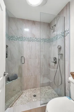 a bathroom with a sink vanity granite tub shower and a mirror