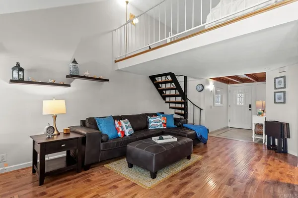 a living room with furniture and a wooden floor