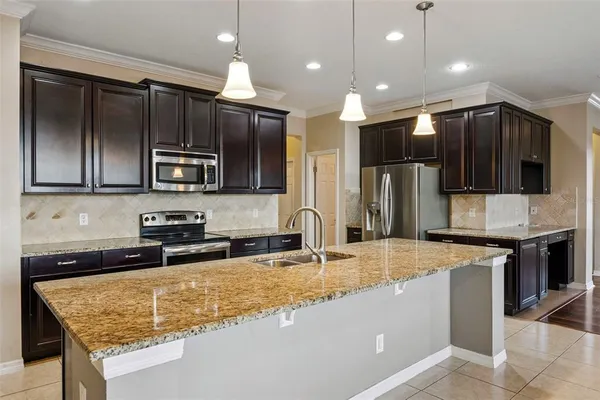 a kitchen with stainless steel appliances granite countertop a sink refrigerator and microwave