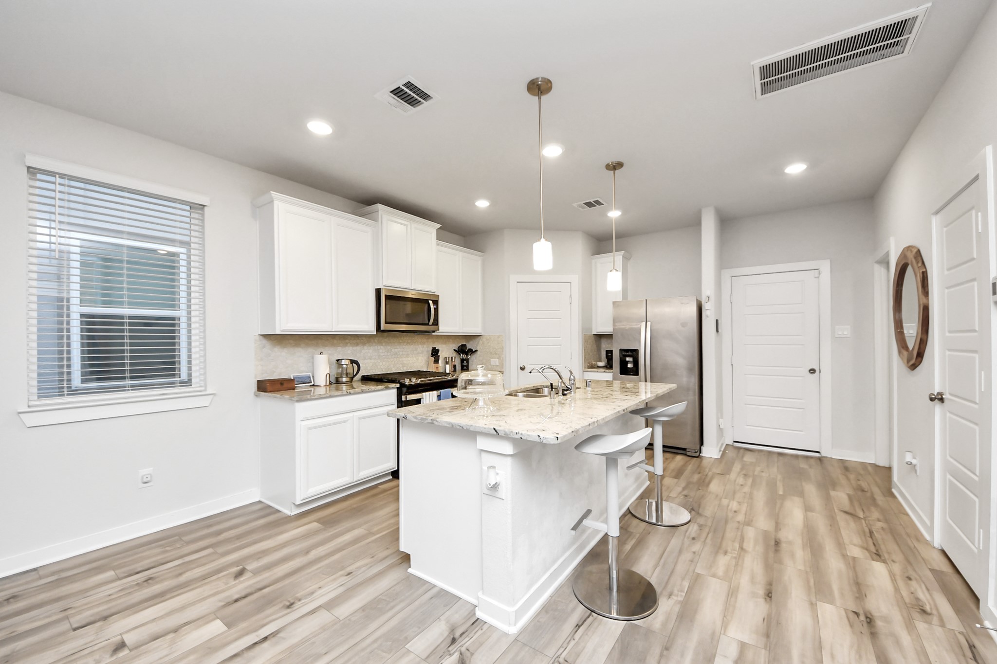 8207 Rising Stream Drive Houston, TX 77063 - Photo 14 of 50 a kitchen with stainless steel appliances kitchen island granite countertop a stove a sink a refrigerator and white cabinets with wooden floor
