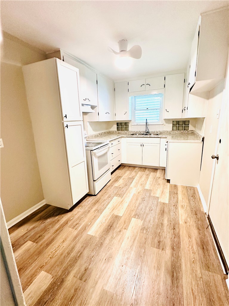 1202 Devon Drive Corpus Christi, TX 78404 - Photo 16 of 19 a large white kitchen with sink and refrigerator