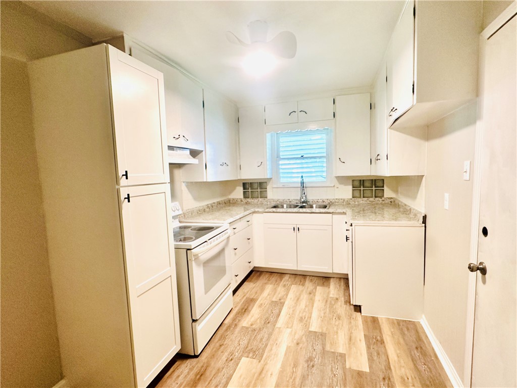 1202 Devon Drive Corpus Christi, TX 78404 - Photo 3 of 19 a kitchen with white cabinets and white appliances