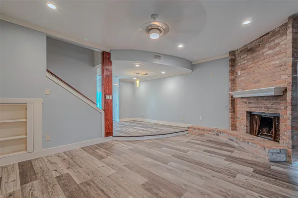 a view of empty room with wooden floor and fireplace