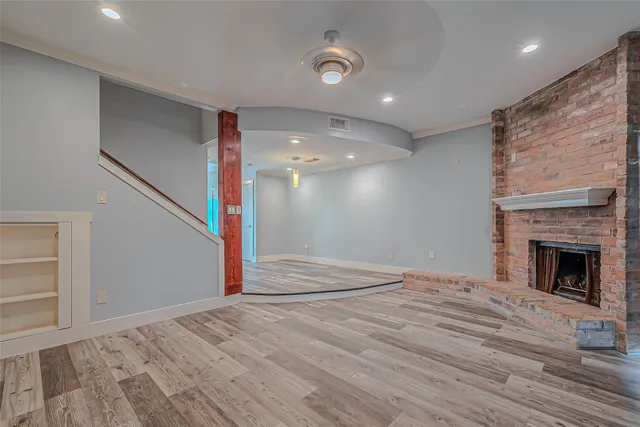 a view of empty room with wooden floor and fireplace