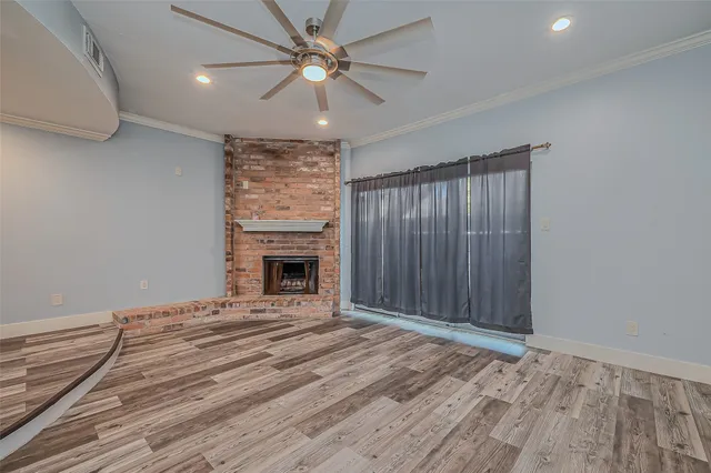 a view of an empty room with a fireplace and a window