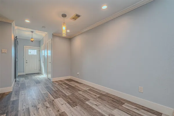 a view of empty room with wooden floor