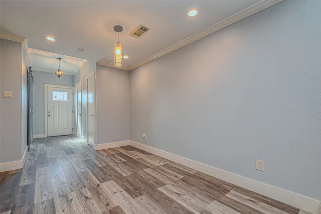 a view of empty room with wooden floor