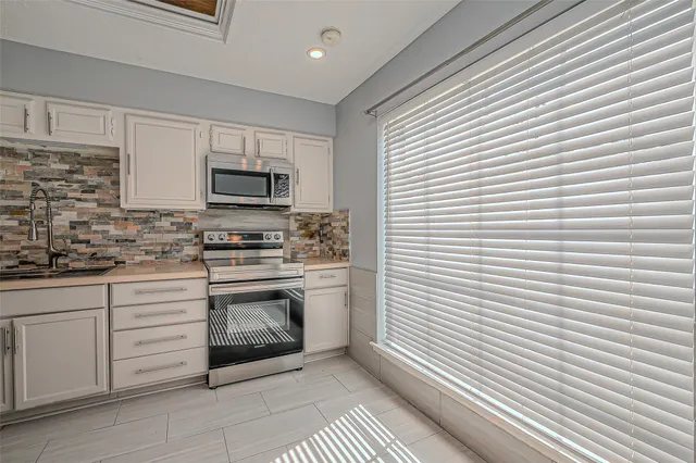 a kitchen with cabinets stainless steel appliances and sink